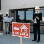 Three real estate professionals inspecting a property for sale with a focus on the business aspect.